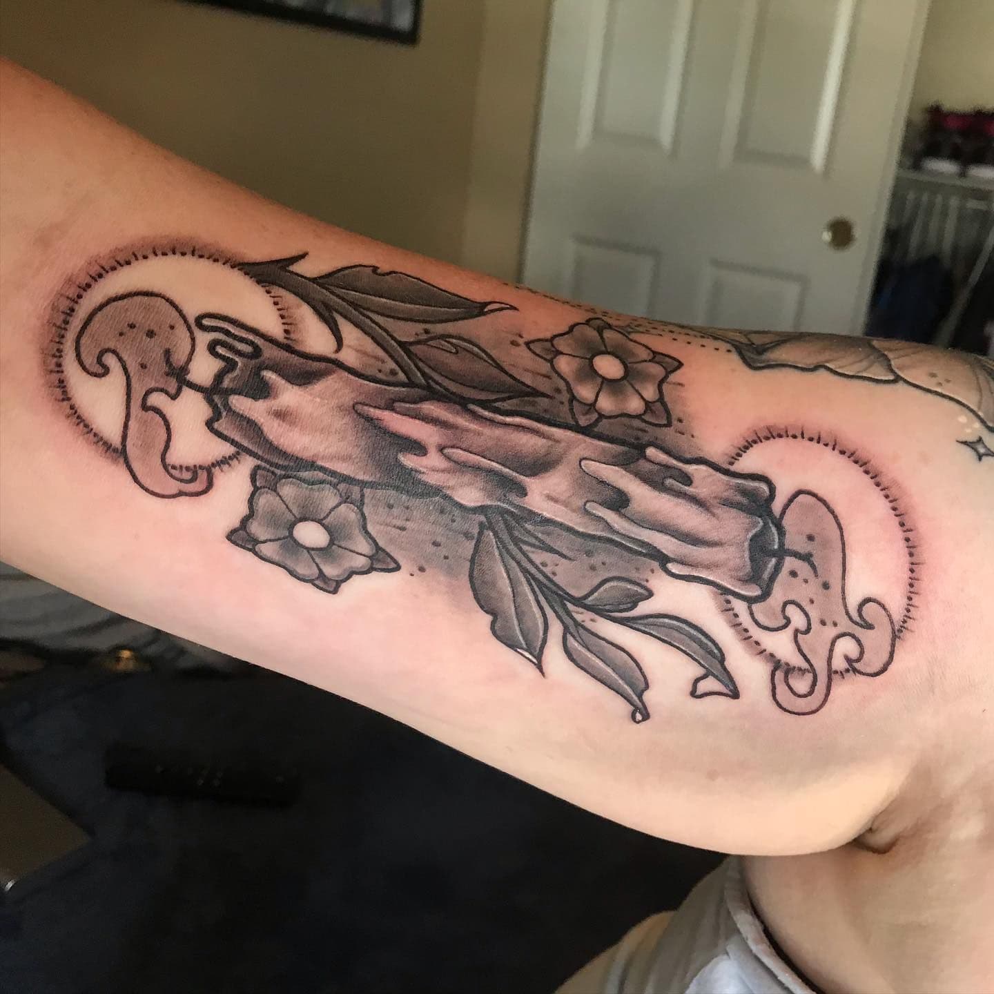 Blackwork illustrative melting candle tattoo on upper arm