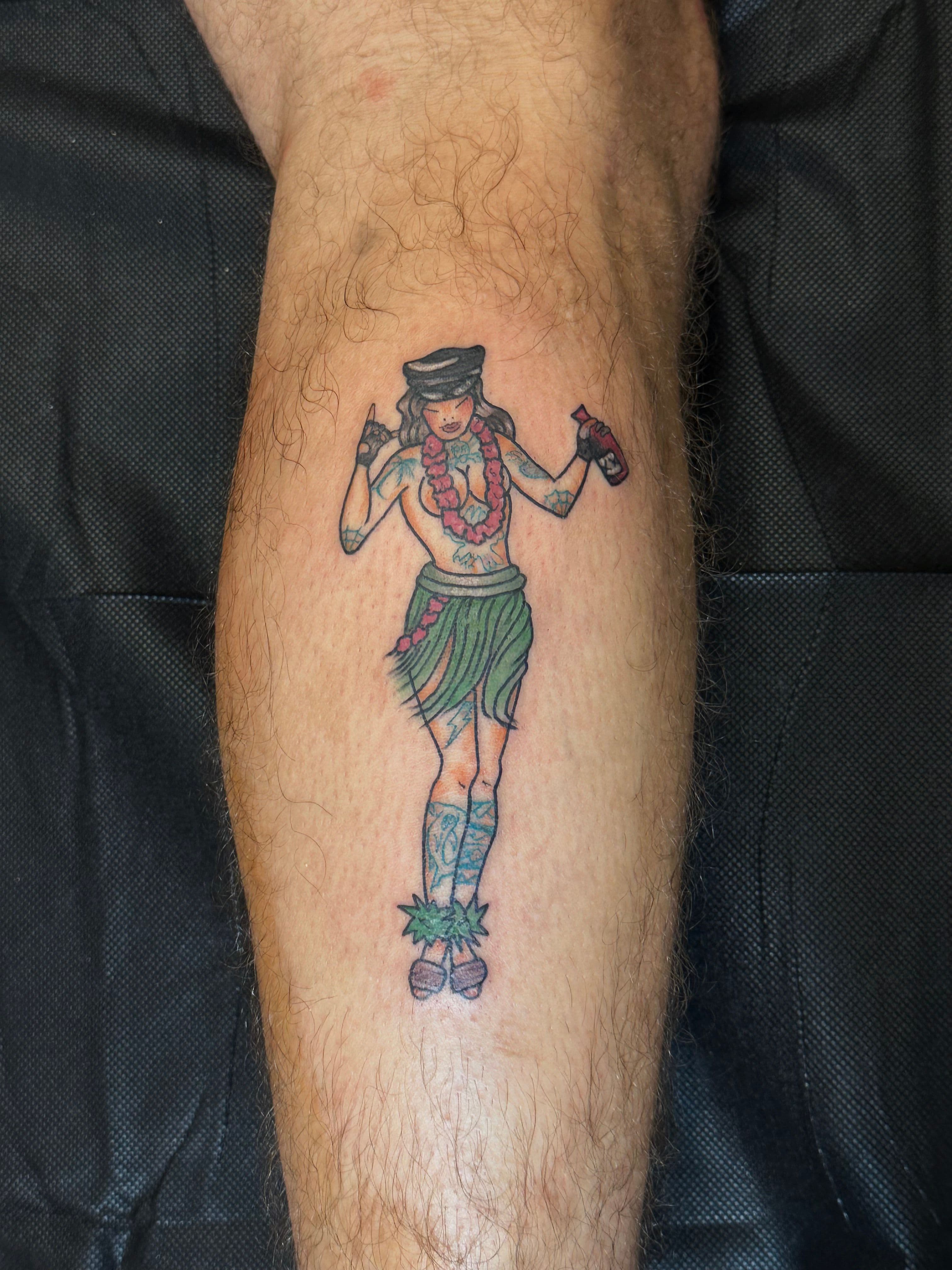 Colorful illustrative hula dancer tattoo on calf.