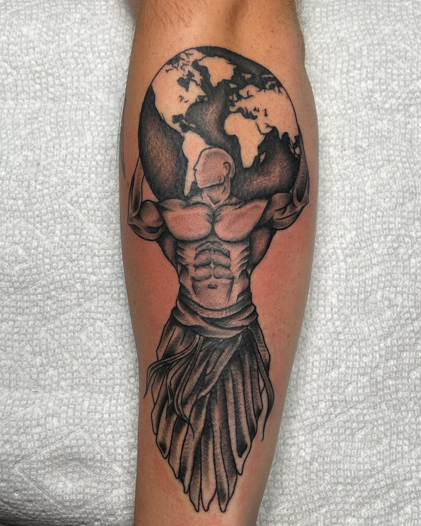Black and grey illustrative Atlas holding globe on calf
