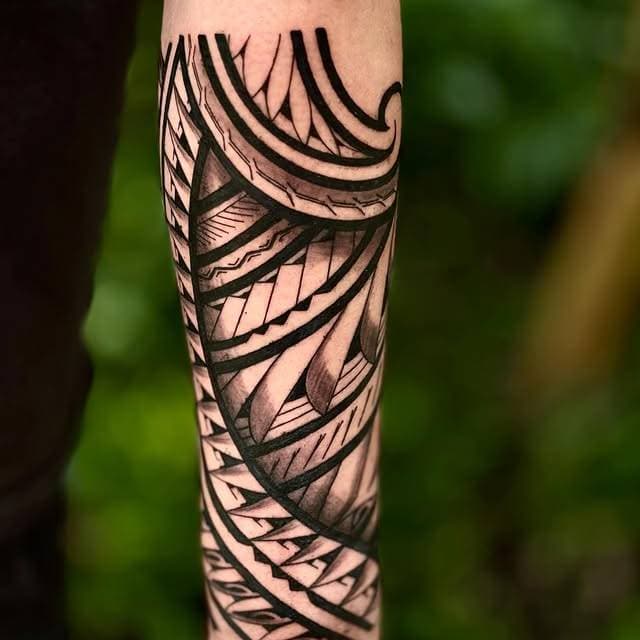 Blackwork geometric tattoo on forearm with intricate patterns and bold lines