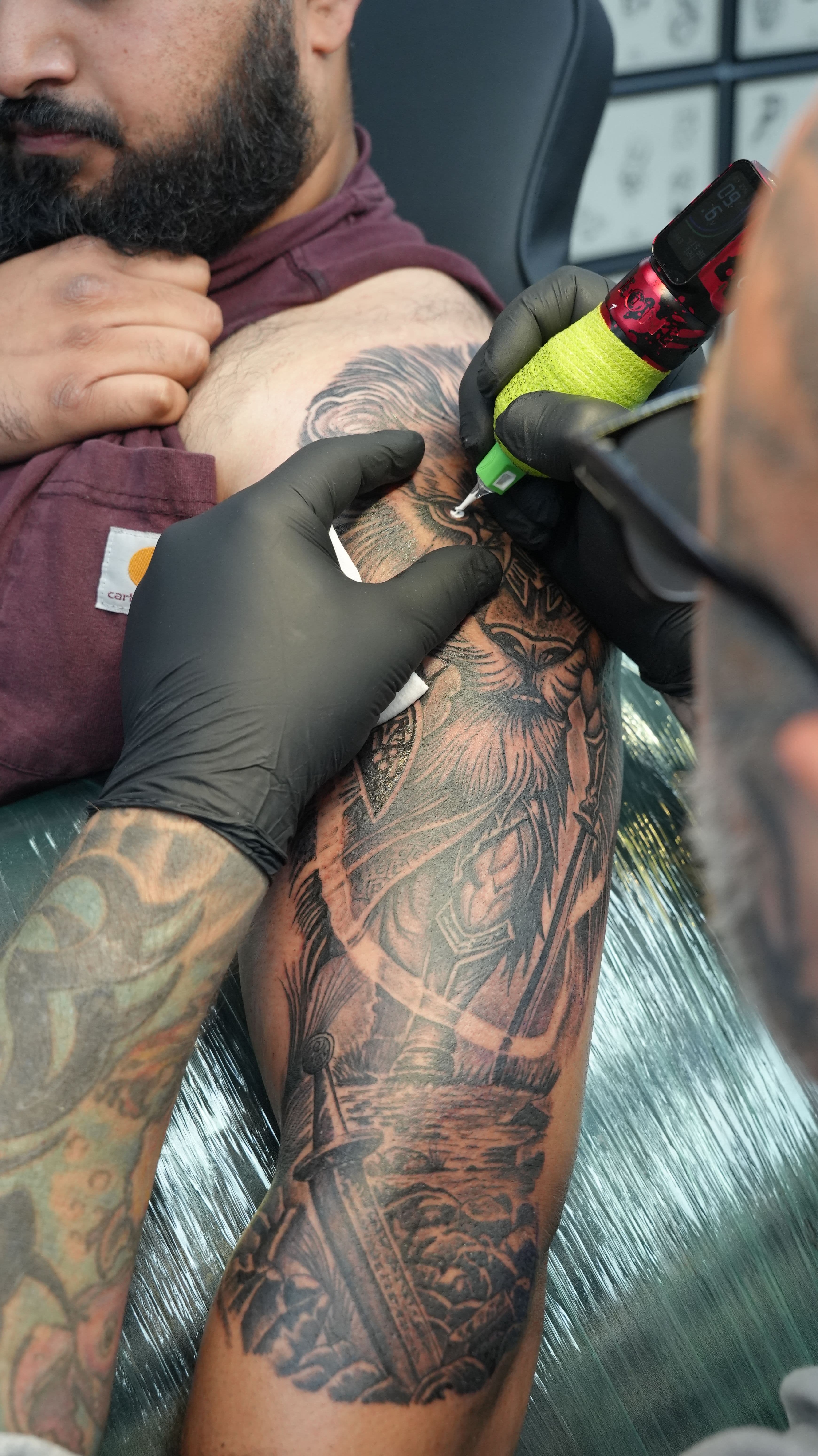 Black and grey illustrative warrior and sword tattoo on upper arm