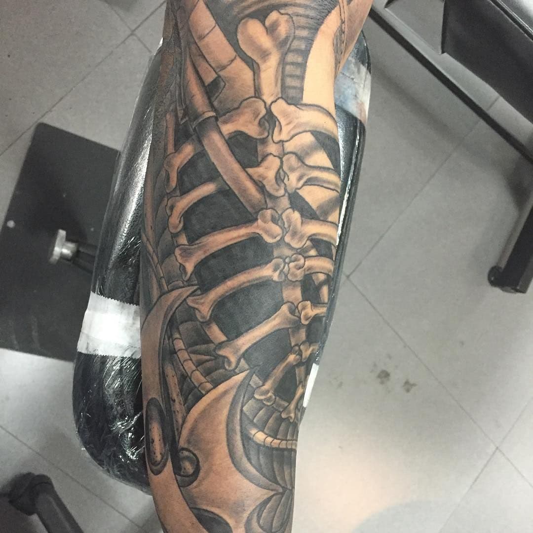 Black and grey biomechanical skeleton tattoo on forearm