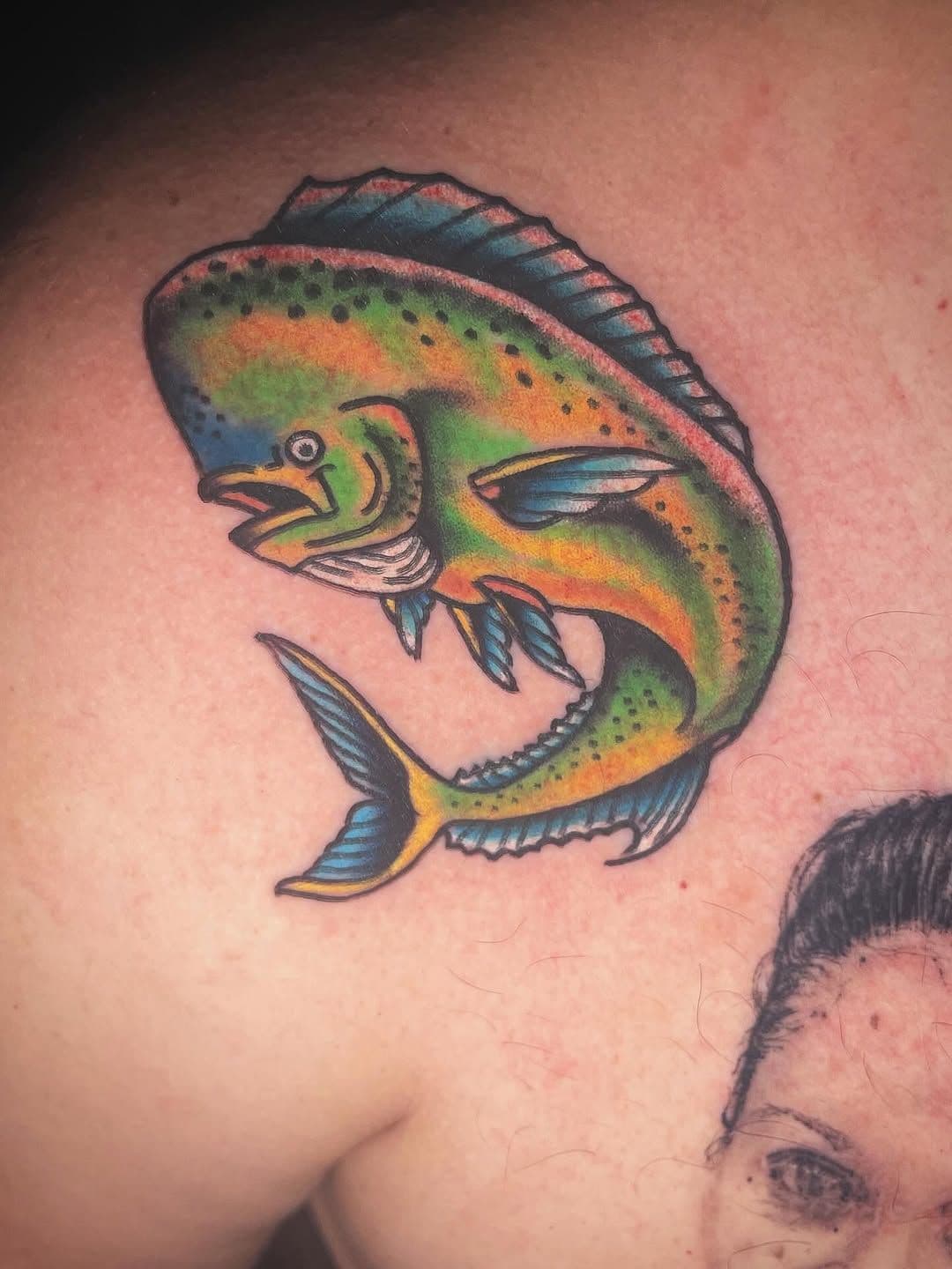 Colorful illustrative fish tattoo on shoulder